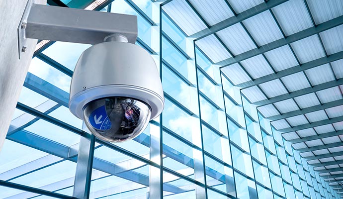 Outdoor dome security camera mounted on a wall, providing surveillance for open indoor spaces