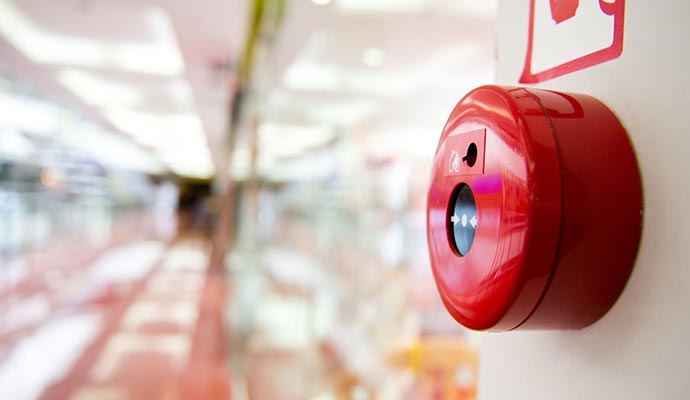 Red fire alarm button mounted on a wall