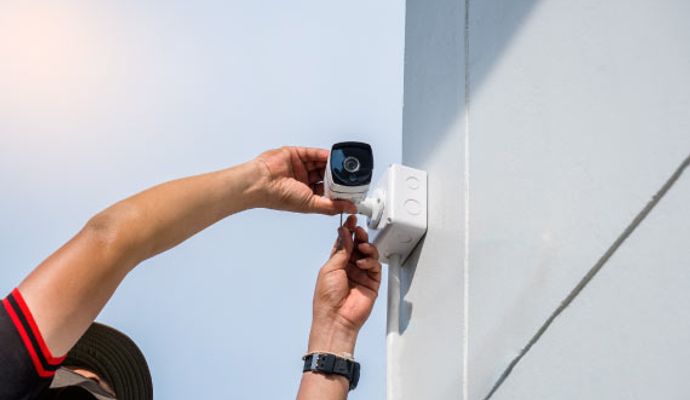 worker installing an outdoor bullet camera